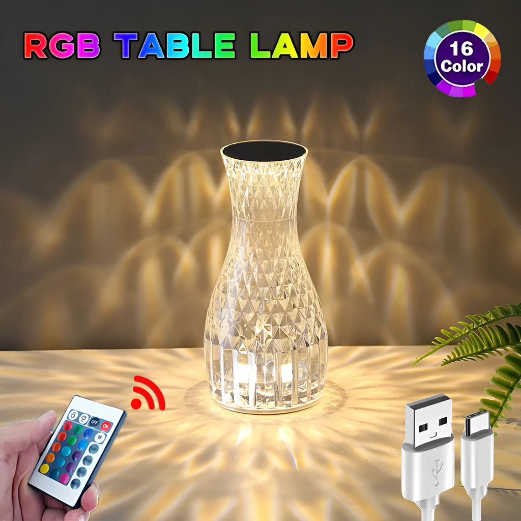 White crystal vase-shaped table lamp with remote control on a wooden surface.