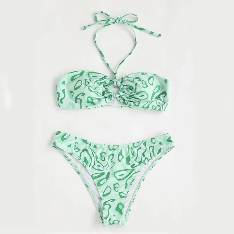 Women's blue floral bandeau bikini swimsuit with split design on beach background