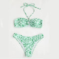 Women's blue floral bandeau bikini swimsuit with split design on beach background