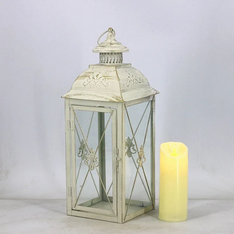 Black wrought iron floor lantern with tempered glass panels, standing on a patio.
