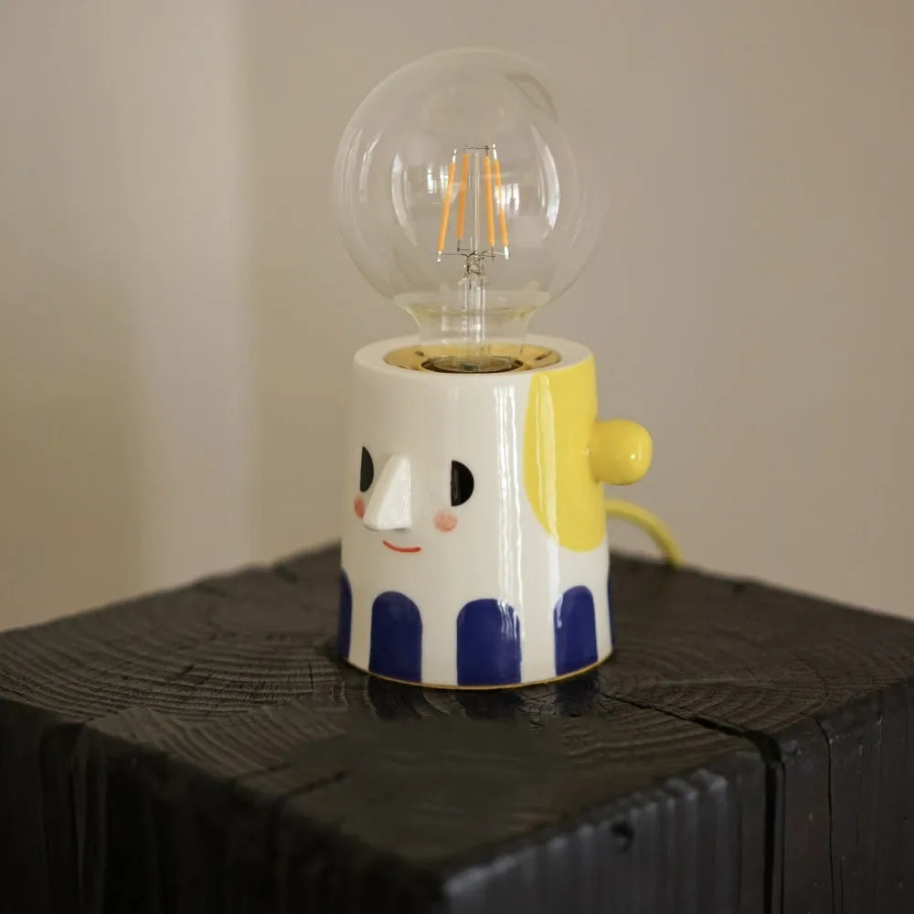 Handmade ceramic bedside lamp with spherical shade on wooden table