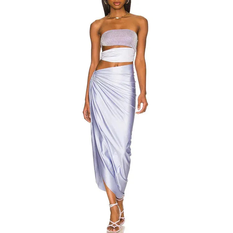 Purple one-piece swimsuit with hollow design and matching wrap skirt on a model.