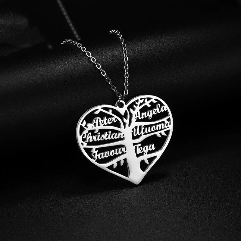 Close-up of a personalised stainless steel necklace with a heart-shaped pendant engraved with names and a family tree design.