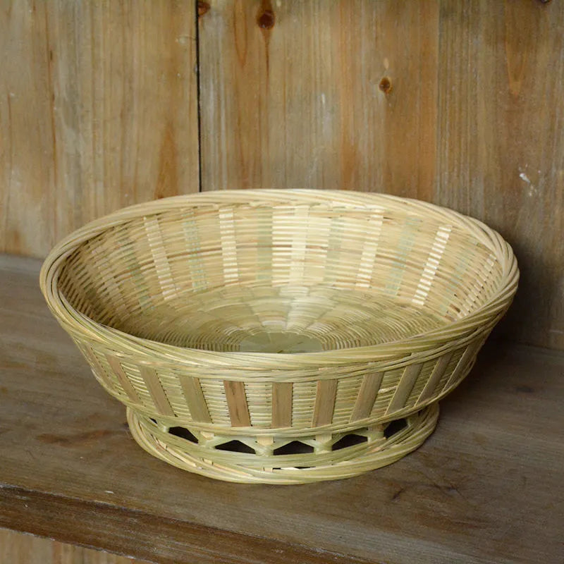 Handmade natural bamboo woven storage basket in three different sizes on a table.