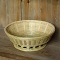 Handmade natural bamboo woven storage basket in three different sizes on a table.