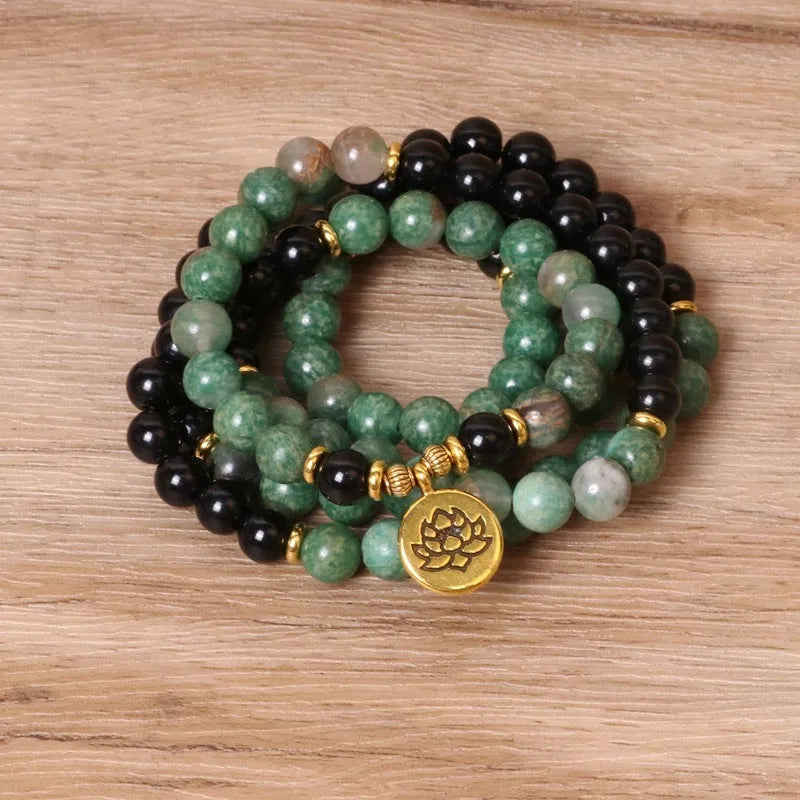 Green and black alloy bead elastic stretch bracelet on a wrist.