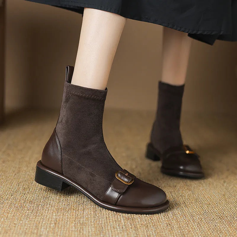 Women's black low heel Martin boots with front lace-up and belt buckle stitch detailing on a white background.