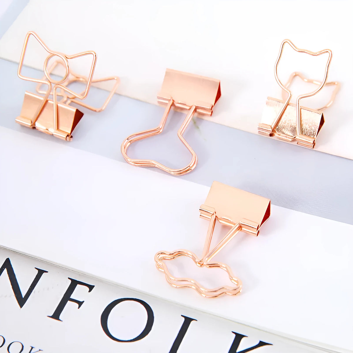 Gold-coloured decorative office paper clips with long tail designs including flamingo, love, cloud, cat, cactus, and bow shapes