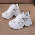 Women's white height increasing dad shoes with cross straps and lace-up front on rubber sole.
