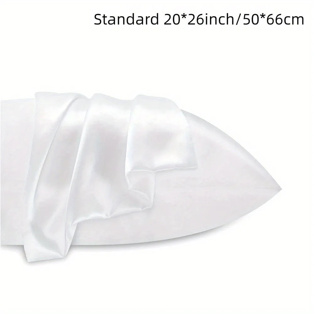 Pair of solid colour satin pillowcases in various sizes on a bed.