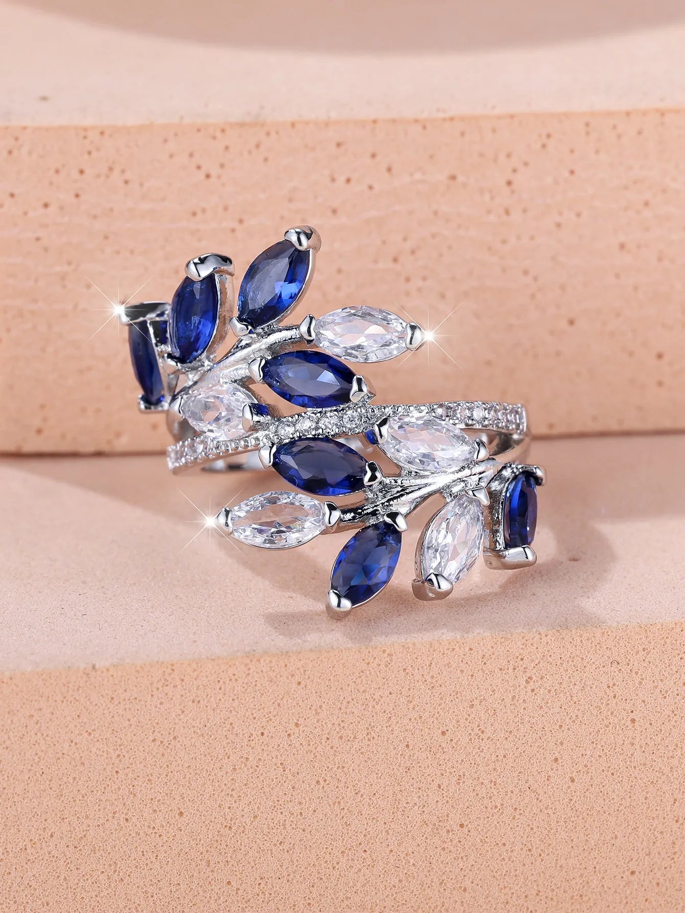 Adjustable opening copper leaf fashion ring with sparkling zirconia stones in a rose gold finish.