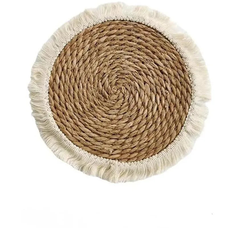 Round papyrus straw placemat with tassel edge in neutral colour on dining table