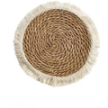 Round papyrus straw placemat with tassel edge in neutral colour on dining table