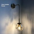 Glass wall lamp with floral pattern in choice of golden or silver finish
