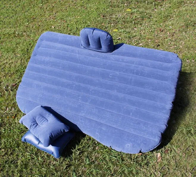 Black inflatable car bed with flocking material and two pillows, shown inside a car.