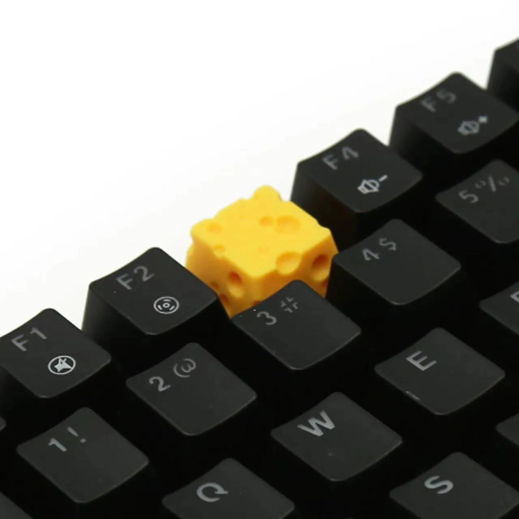 Close-up of a yellow solid resin cheese-themed keycap for mechanical keyboards.