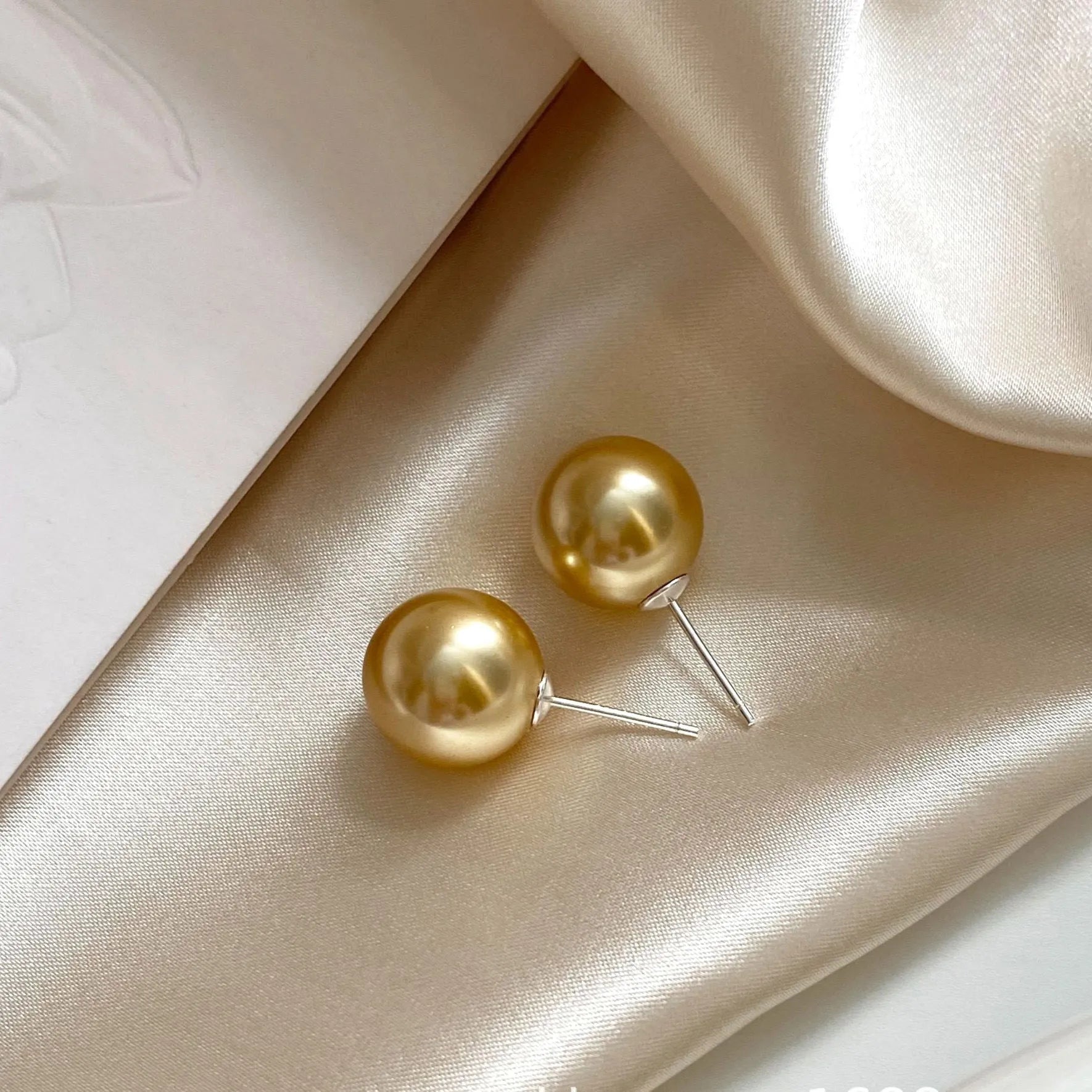 Large retro-style pearl stud earrings for women with a geometric eight-pointed star setting.