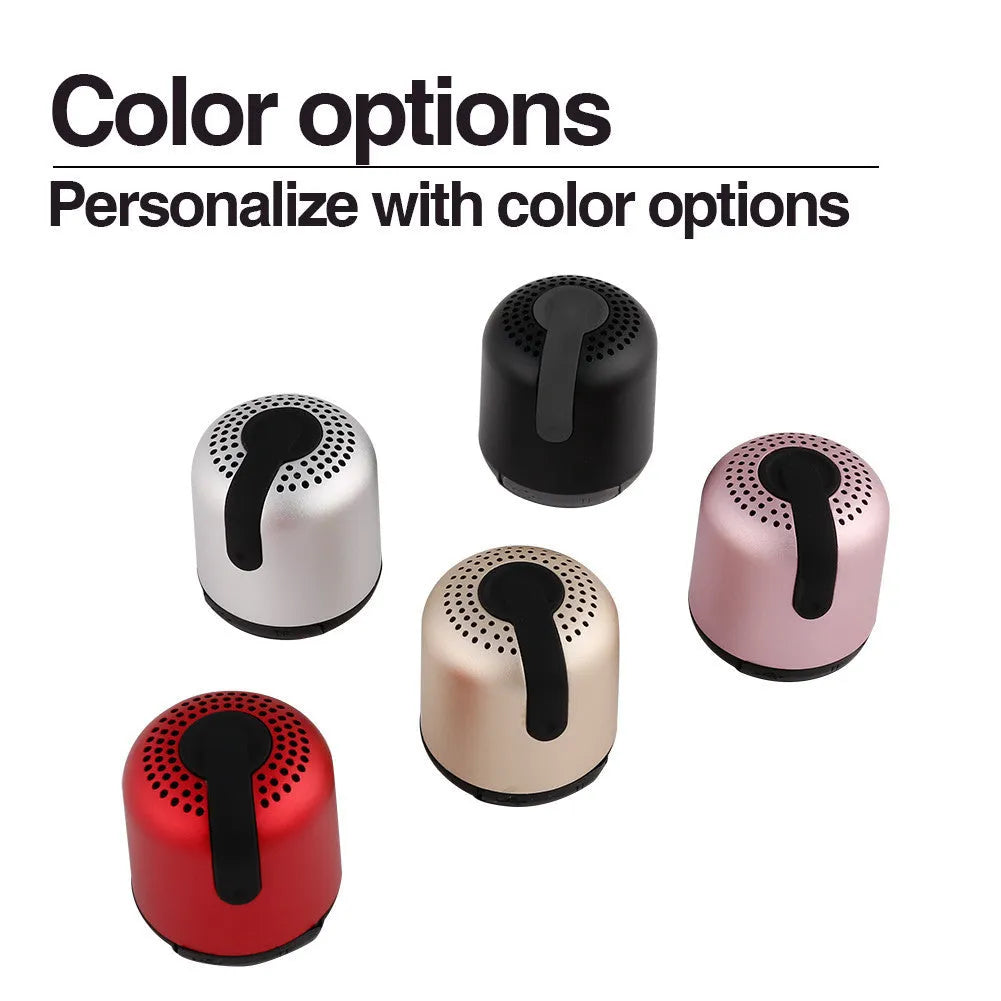 Hieha XQ11 cylindrical mini portable Bluetooth speaker in silver colour on a table.