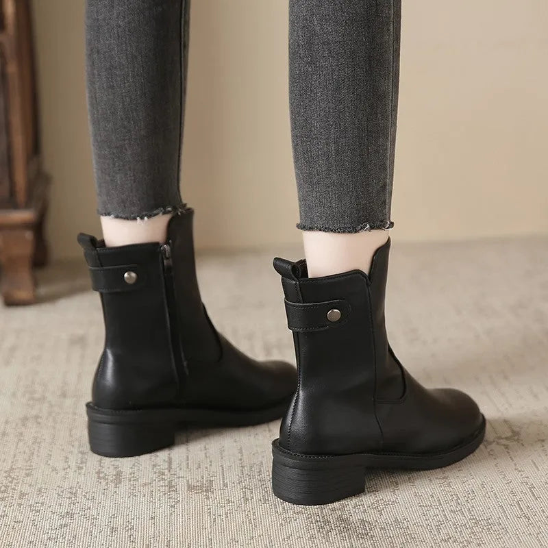 Black women's low heel ankle boots with side zip and round toe on a rubber sole