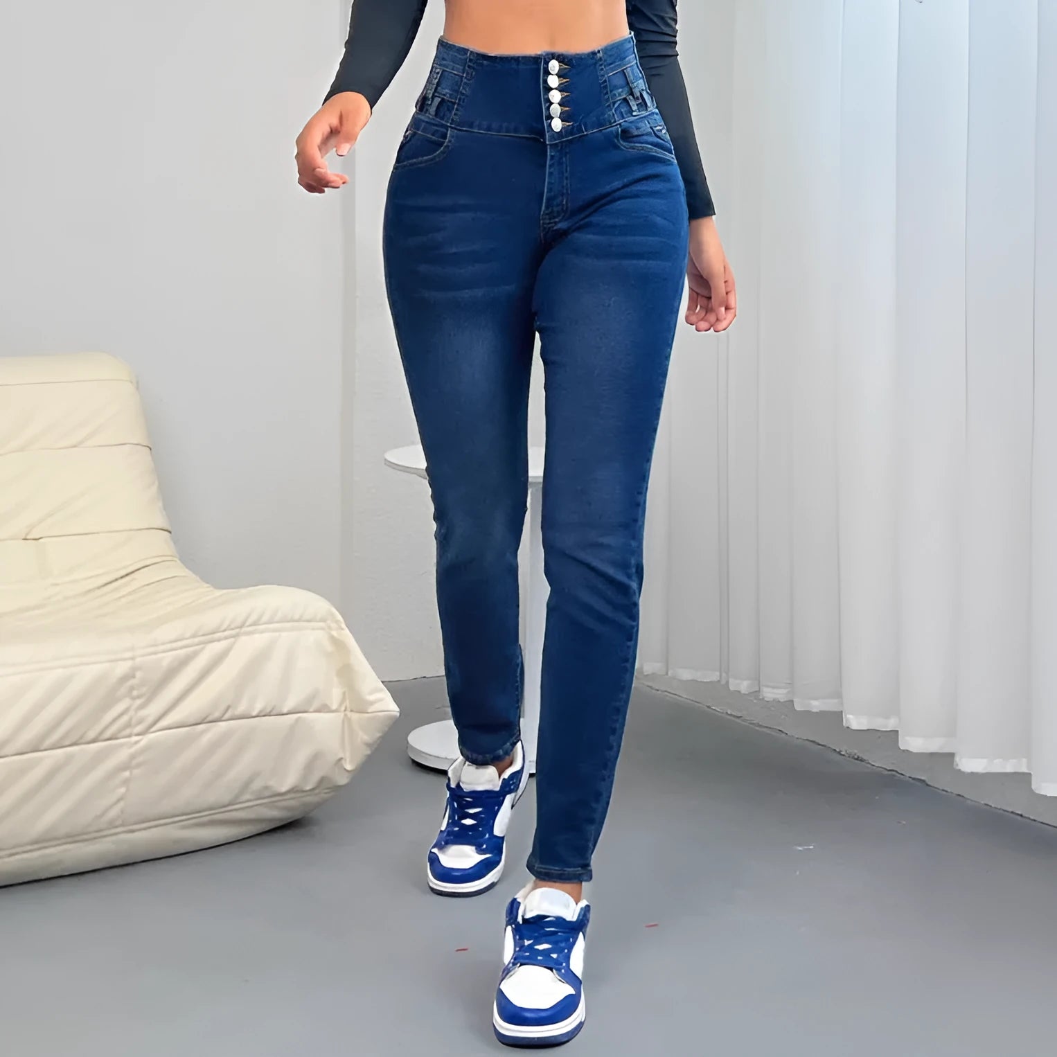 Dark blue women's straight-leg denim trousers with button details on a hanger.