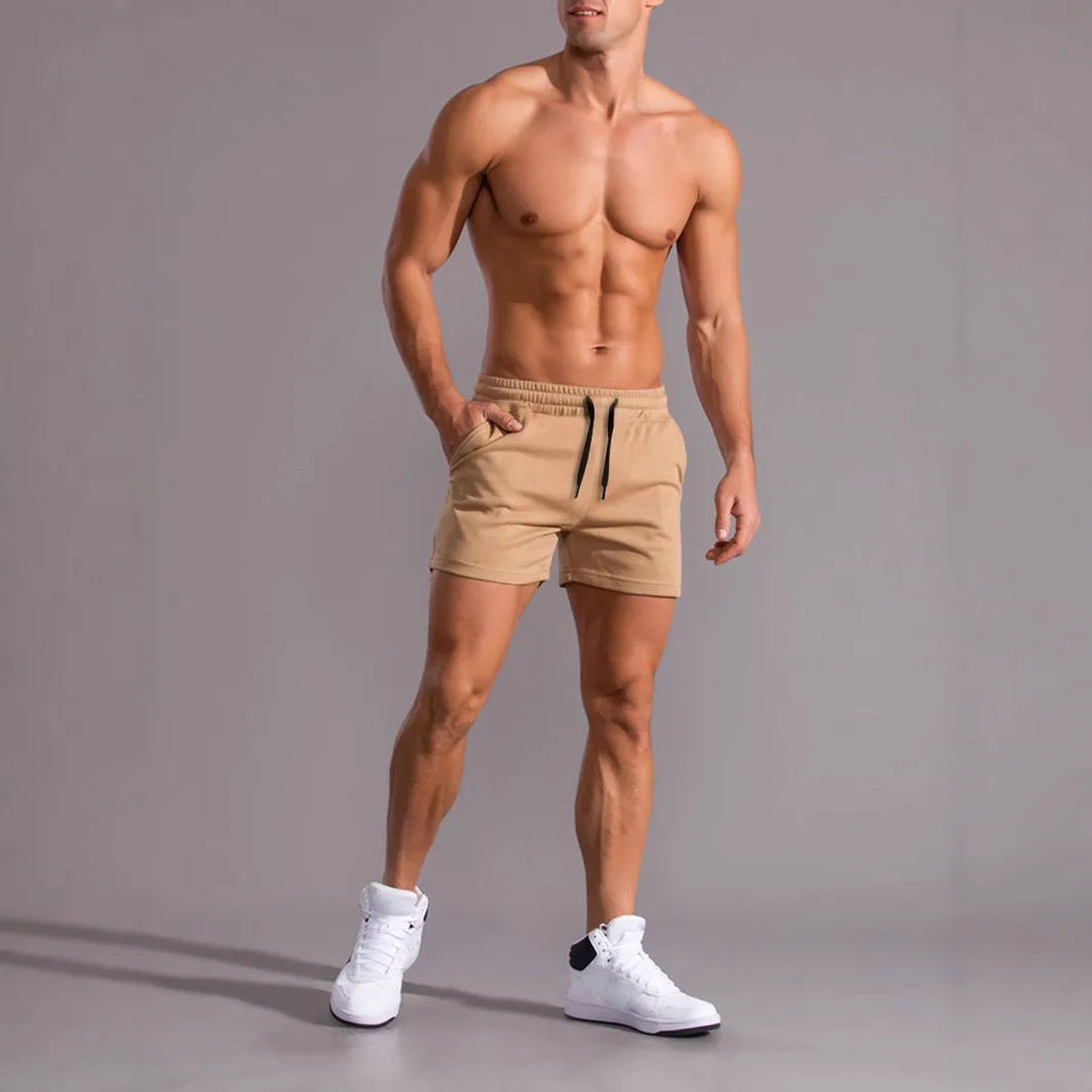 Men's black, khaki, and light brown elastic drawstring shorts laid flat, showing loose fit and adjustable waistband.