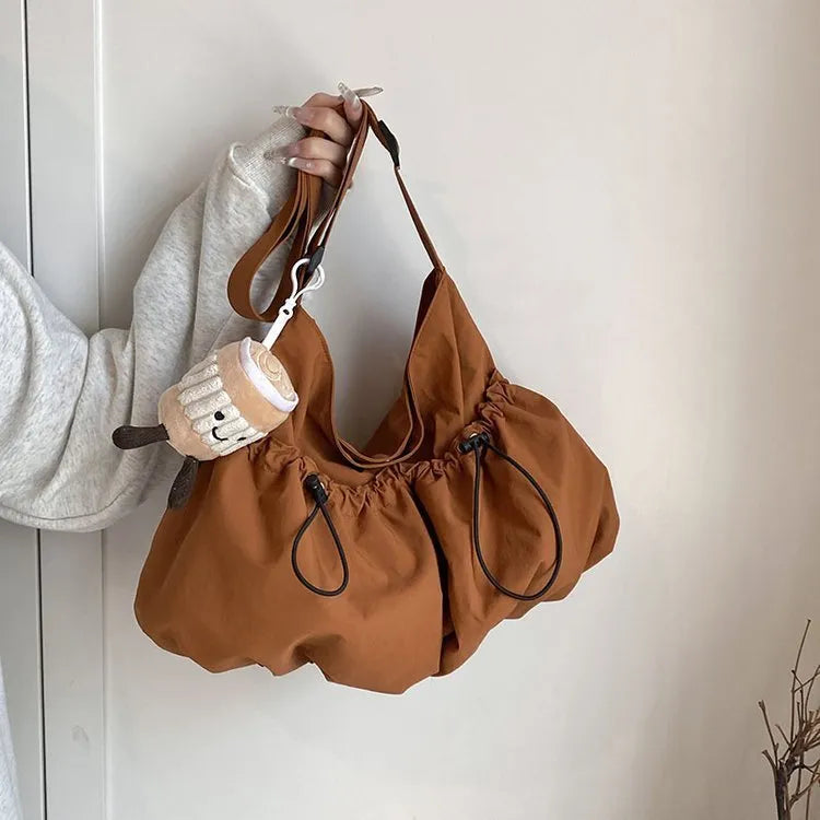 Green pleated foldable polyester crossbody bag showing split pocket and internal phone compartment.
