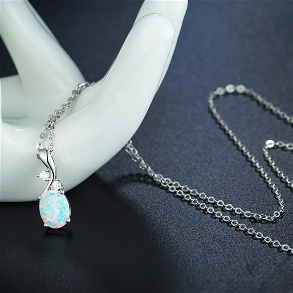 Water drop shaped opal pendant on an adjustable silver tone necklace chain