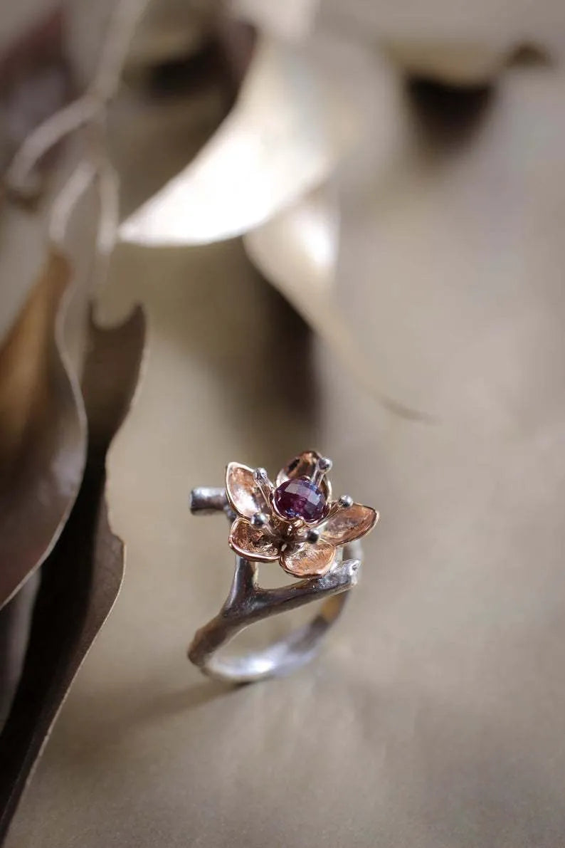 Silver two-tone women's floral ring with a simple geometric shape on a neutral background.