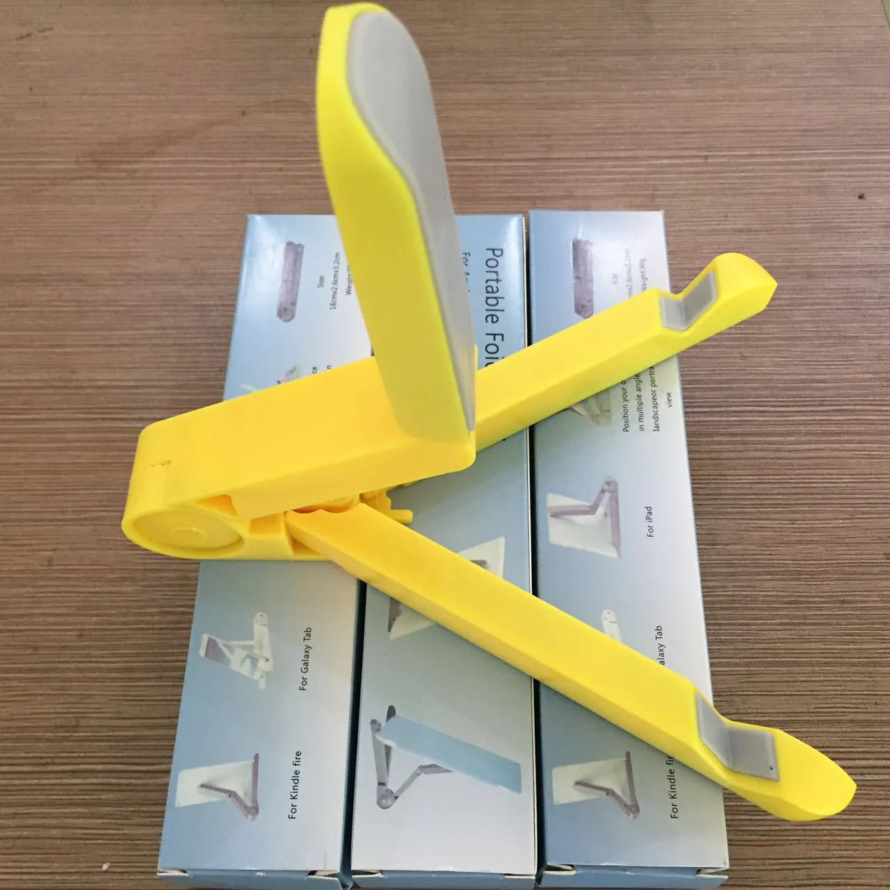 Black foldable tablet holder open in landscape mode holding a smartphone, showing its adjustable angle and non-slip base.