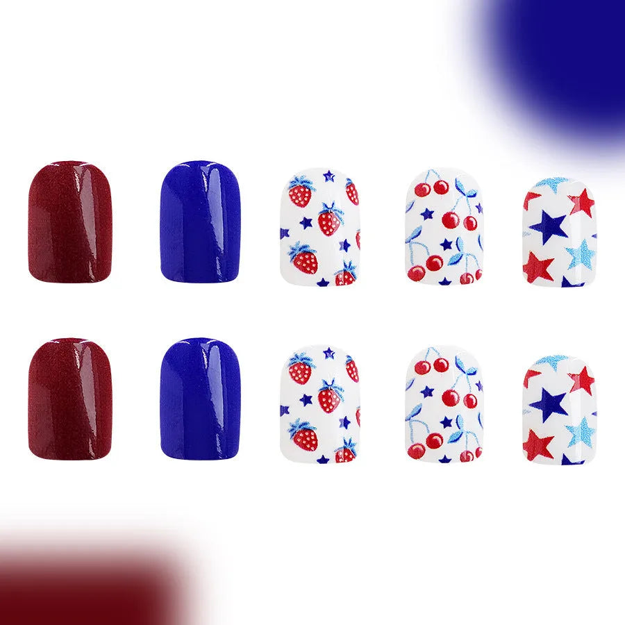 Short glossy false nails with strawberry cherry independence day patterns in red and blue