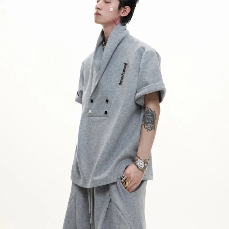 Men's dark grey cotton V-neck sports suit with padded shoulders, metal details, and matching shorts.