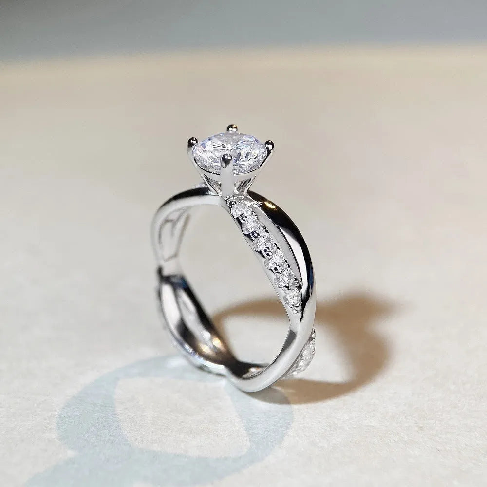 Geometric cross-design silver ring with a 1 karat moissanite stone in a four-claw setting.