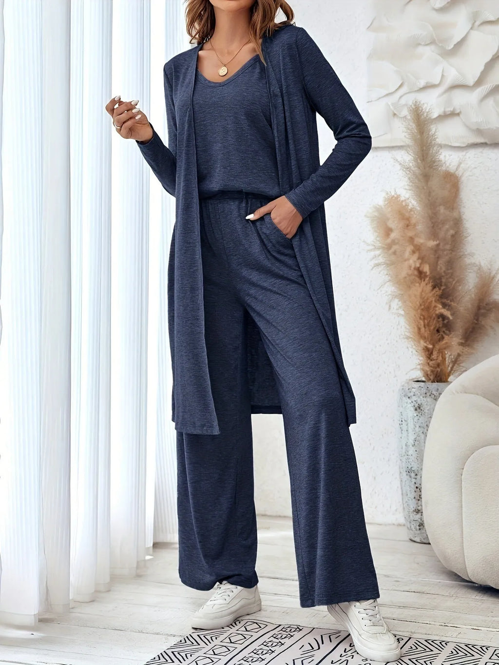 Blue women's three-piece casual suit set comprising sling top, long cardigan, and trousers on a hanger.