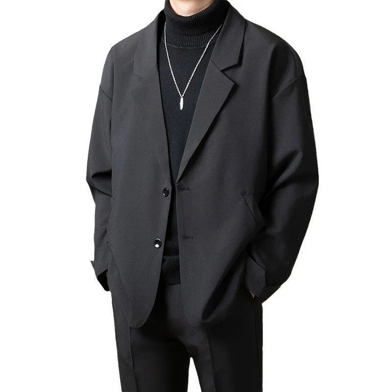 Man wearing a loose-fit apricot coloured casual suit jacket with long sleeves.