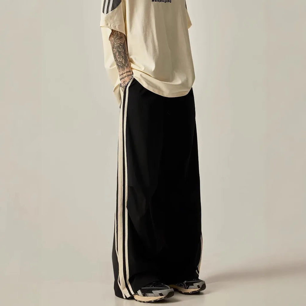 Men's black climbing trousers with high waist and wide straight leg design on hanger