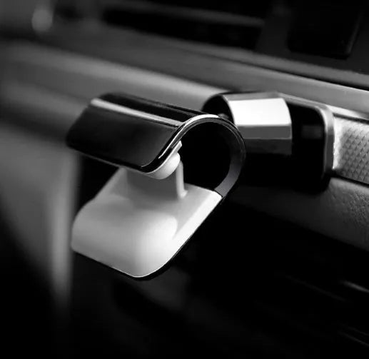 Black 360-degree rotating car phone holder mounted on car air vent with smartphone attached