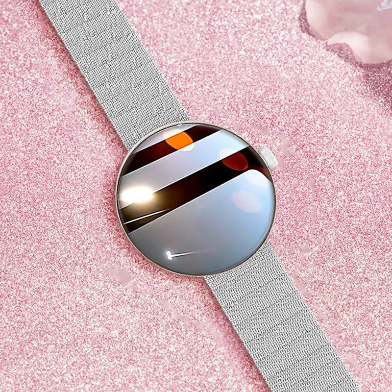 Circular smartwatch for women with metal strap and colour touchscreen on a wrist.