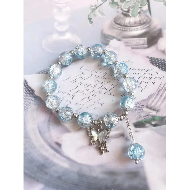 A Chinese style glass bracelet with bamboo leaf and bead designs on a wrist.