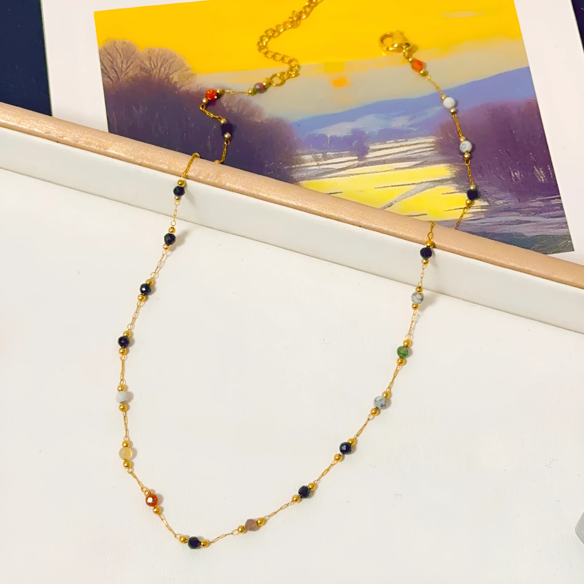 Gold electroplated titanium steel necklace with a natural stone pendant on an O-ring chain.