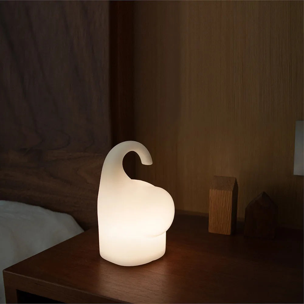 DOMI Elephant-shaped silicone night light in white with warm LED glow on a bedside table.