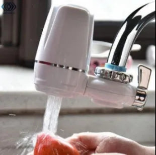 White plastic faucet water filter with adapter kit and ceramic cartridge for kitchen tap installation.