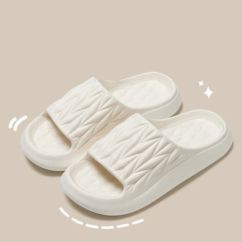 Pair of grey EVA foam slippers with leaf texture pattern and non-slip sole.