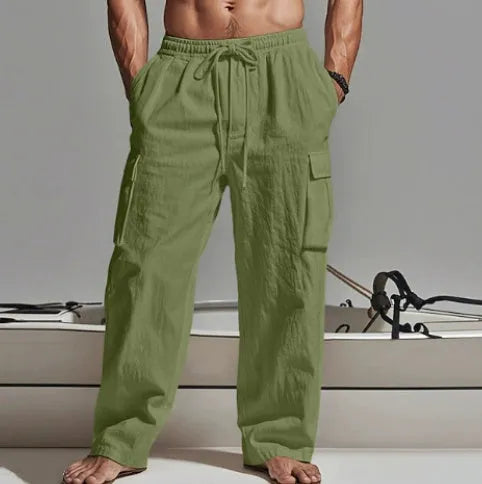 Man wearing loose-fit khaki cotton casual trousers with a wide-leg cut and elasticated waist.