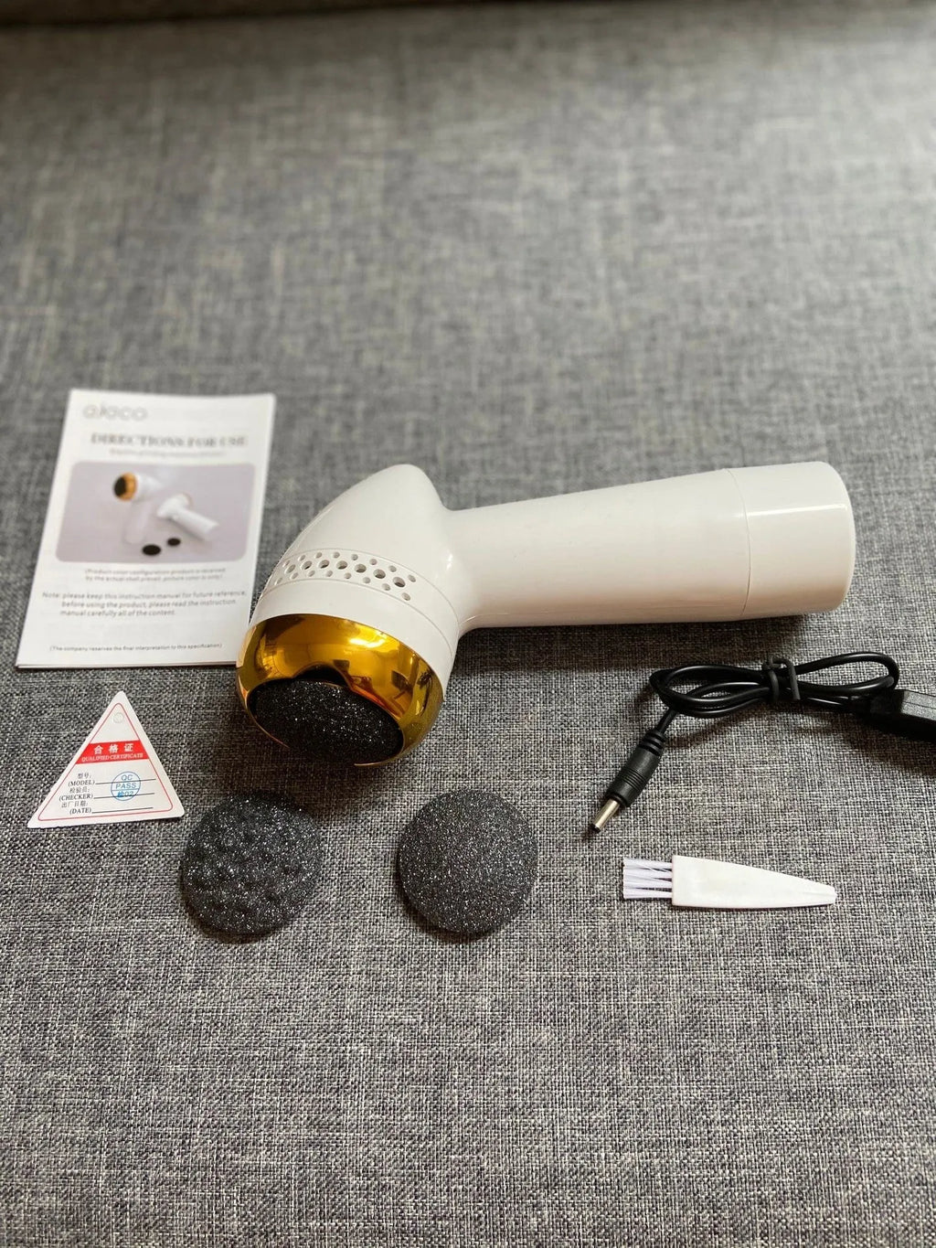 Electric vacuum foot grinder with quartz head in gold colour, showing battery and callus removal function.