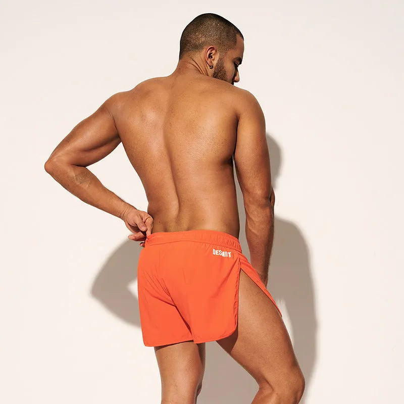 Men's loose-fit beach surf shorts in polyester available in orange, green or black colours