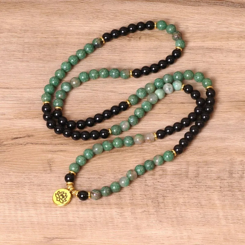 Green and black alloy bead elastic stretch bracelet on a wrist.