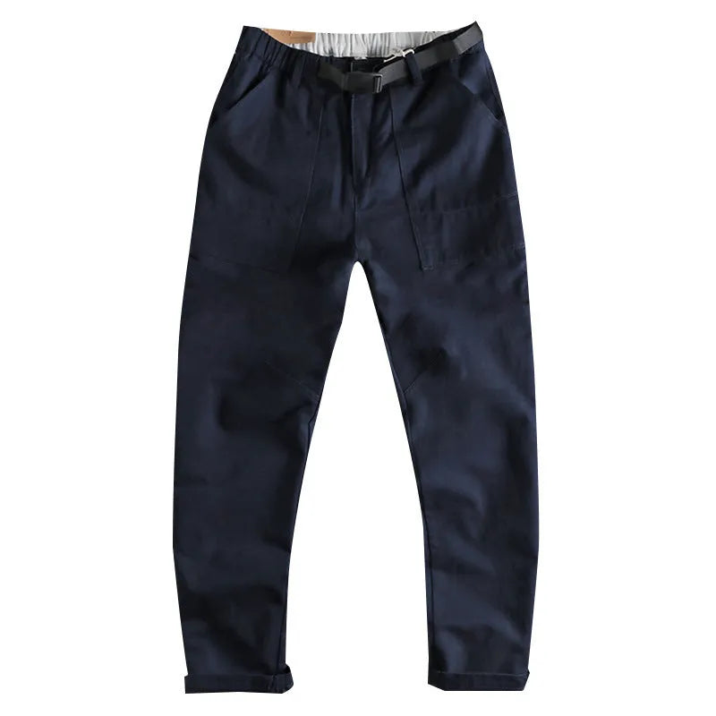 Men's khaki cotton work trousers with mid waist and zipper fly on a neutral background