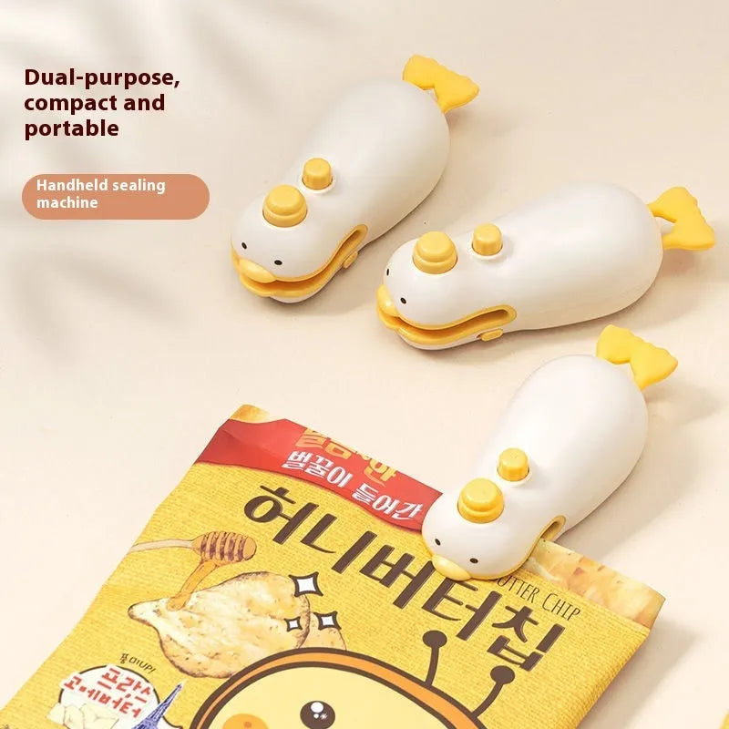 Yellow duck patterned rechargeable handheld vacuum food sealer with USB charging cable.