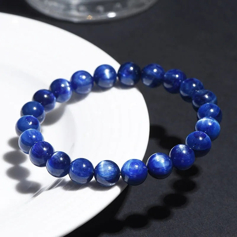 Polished blue crystal ball bracelet with Ruyi charm on a white background.