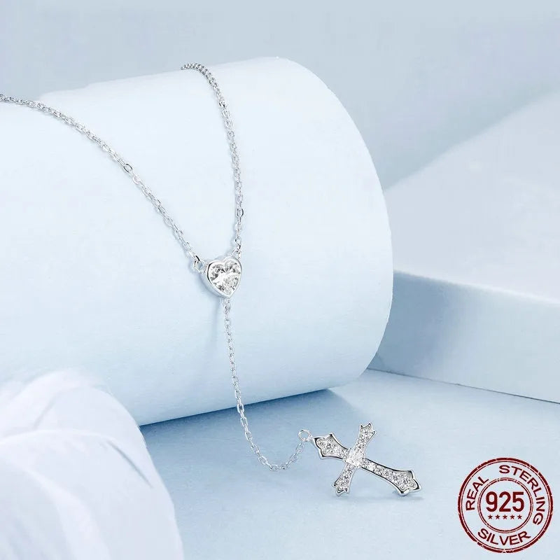 Close-up of a silver love cross necklace with an adjustable O-ring chain on an antique BSN384 finish.